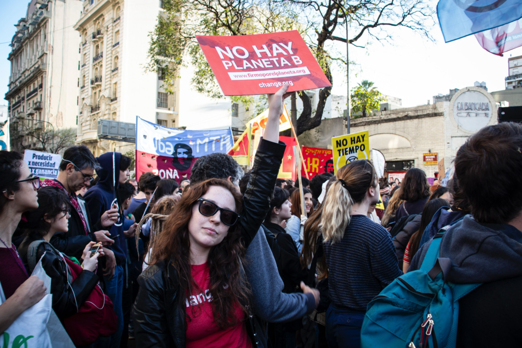 Young woman in a protest holding a sign stating 'No planet B'.